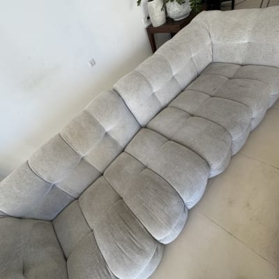 ספת בד אפורה מרופדת ונקייה בסלון ביתי