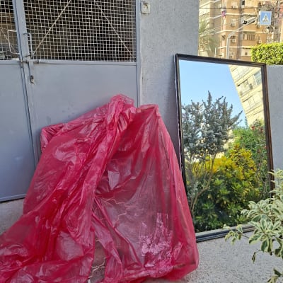 מראה גדולה ליד קיר עם רשת וברזנט אדום