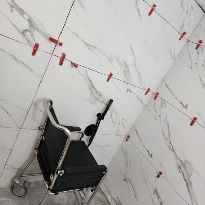 קליפסים אדומים על קיר אריחים לבנים