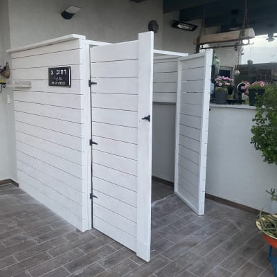 מבנה עץ לבן עם דלתות פתוחות על רצפת עץ