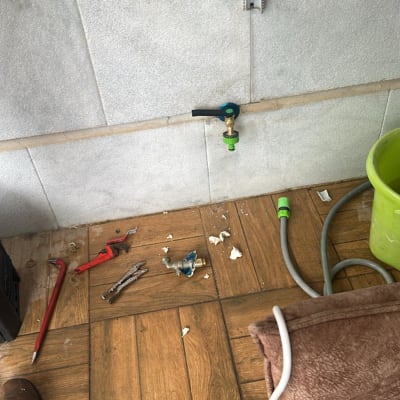 ברז וכלי עבודה על רצפה, דלי ירוק וצינור