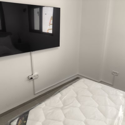 טלוויזיה תלויה על הקיר עם חיבורי חשמל