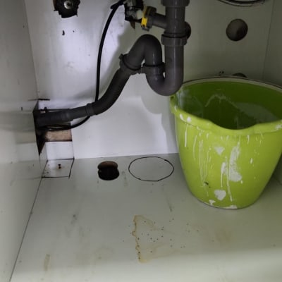 צינור ניקוז מתחת לכיור עם דלי ירוק