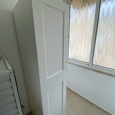 ארון לבן עומד ליד חלון זכוכית מט