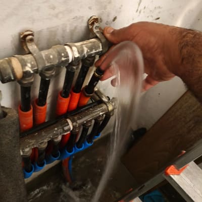 יד מחזיקה צינור מים עם זרם מים זורם