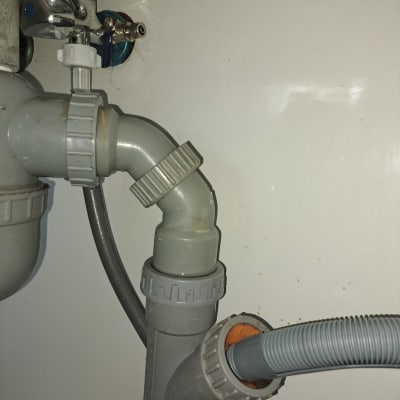 צנרת פלסטיק מתחת לכיור עם מחברים וברזים