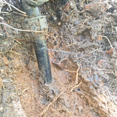 צינור פלסטיק עם נזילה באדמה רטובה