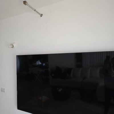 טלוויזיה תלויה על קיר עם כבל חשמל