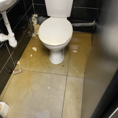 אסלה עם נזילה על הרצפה בחדר שירותים