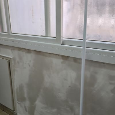 קיר צבוע עם חלון ומוט צביעה