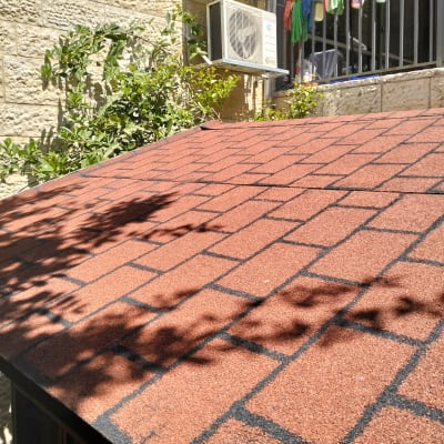 גג רעפים אדום עם צללים של צמחים