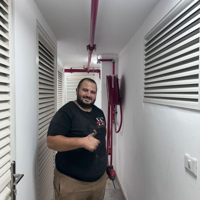 אדם עומד ליד צינור כיבוי אש במסדרון