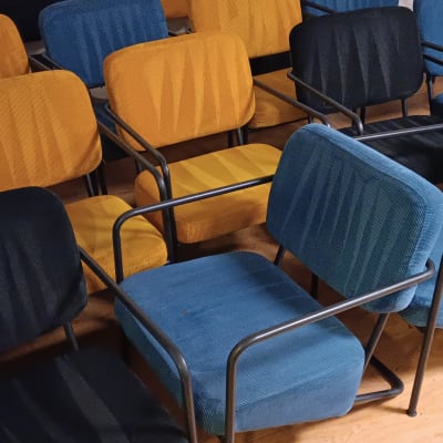 כיסאות מרופדים בצבעים שונים מסודרים בחדר