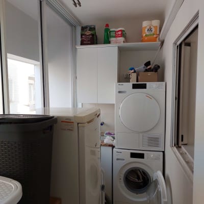 חדר כביסה עם מכונת כביסה ומייבש