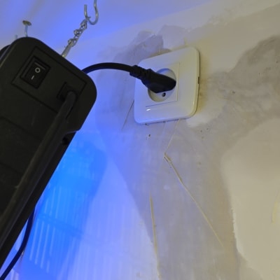 תקע חשמלי מחובר לשקע בקיר עם תאורה כחולה