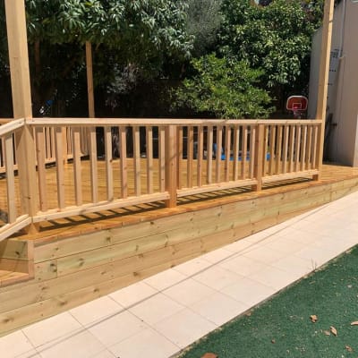 דק עץ עם מעקה בגינה