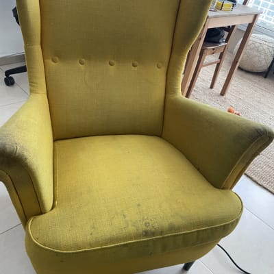 כורסה צהובה עם כתמים, צינור ניקוי על הרצפה