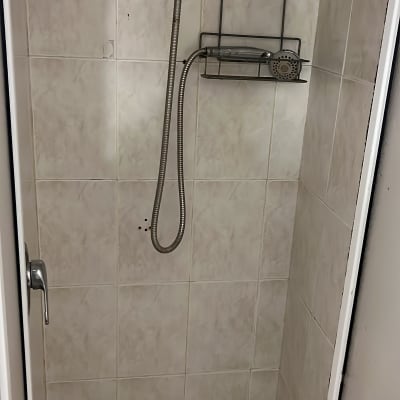 מקלחת עם ראש מקלחת ומדף מתכת