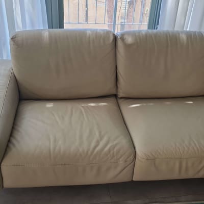 ספה בהירה עם כריות במרכז החדר