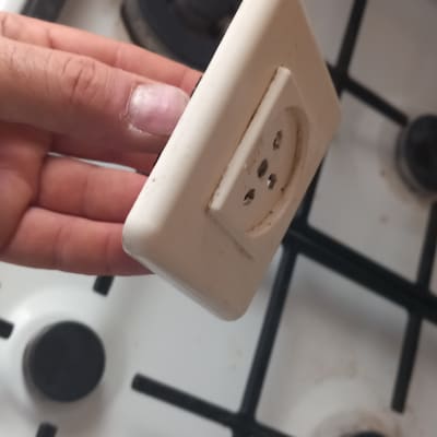 שקע חשמלי מוחזק ביד מעל כיריים