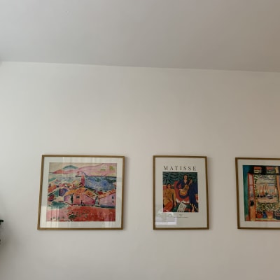 שלושה ציורים ממוסגרים תלויים על קיר לבן