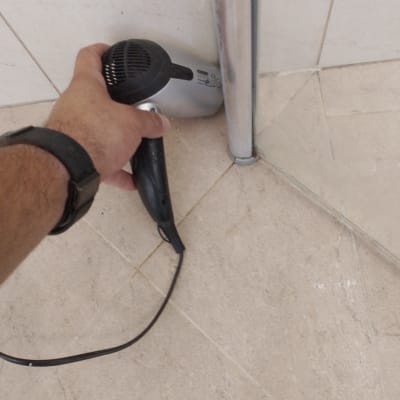 ייבוש אזור עם מייבש שיער ליד צינור מתכת