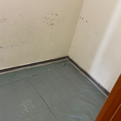 קיר עם סימני צבע ויריעת מגן על הרצפה