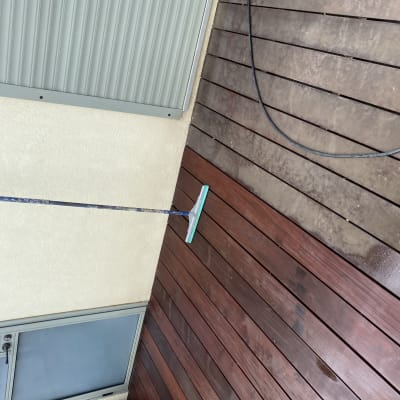 מגב על רצפת עץ רטובה ליד קיר