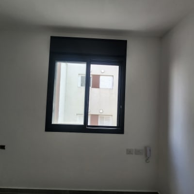 חלון אלומיניום עם מסגרת שחורה בקיר לבן