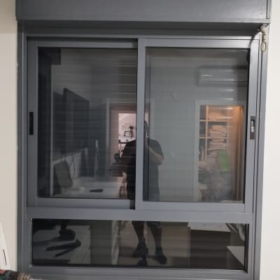 תריסים אפורים בחלון זכוכית עם מסגרת מתכת