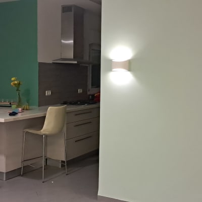 קיר צבוע במטבח עם כיסאות אדומים ושולחן לבן