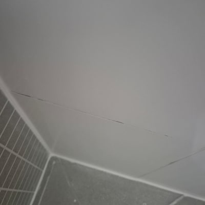 סדק בקיר אריחים בפינת חדר אמבטיה