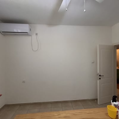 חדר עם קיר צבוע, מאוורר תקרה ומזגן