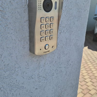 אינטרקום עם מצלמה ומקשים על קיר חיצוני