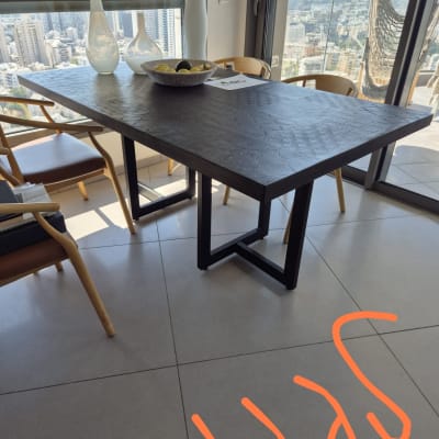 שולחן עץ עם כיסאות ומבט לעיר דרך חלון גדול