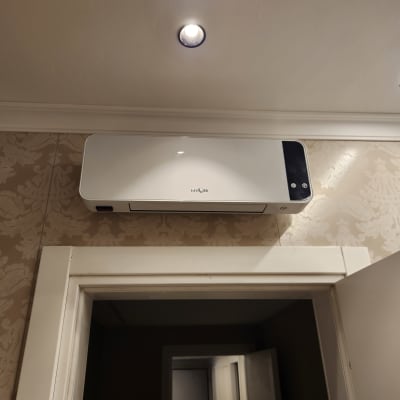 מזגן מותקן על קיר בחדר עם תאורה עליונה