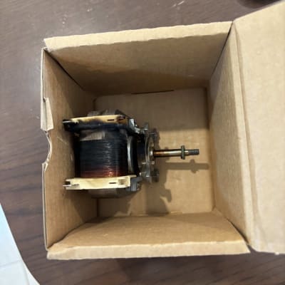 רכיב חשמלי בתוך קופסת קרטון על שולחן עץ