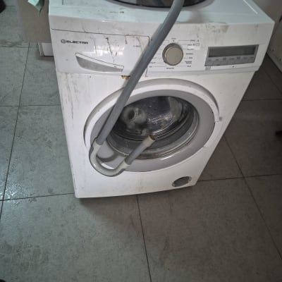 מכונת כביסה עם צינור עליון ולוח בקרה