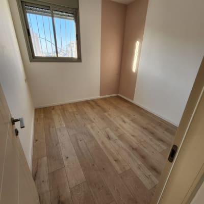 רצפת פרקט עץ בחדר ריק עם קירות לבנים