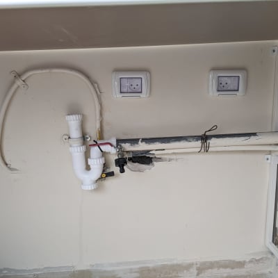 צנרת פלסטיק לבנה עם חיבורים מתחת לכיור