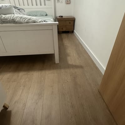 רצפת עץ בחדר שינה עם מיטה ושידה