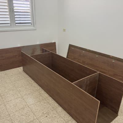 חלקי רהיטים מפורקים על רצפה בחדר