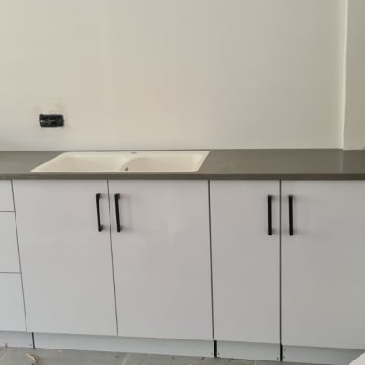 שיש אפור על ארונות מטבח לבנים עם כיור