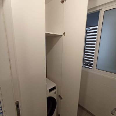 ארון לבן עם דלתות פתוחות ומכונת כביסה בפנים