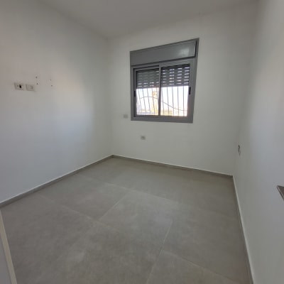 חדר ריק עם רצפה נקייה וקירות לבנים