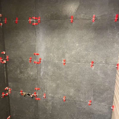 קיר עם אריחים כהים ומחברים אדומים להתקנה