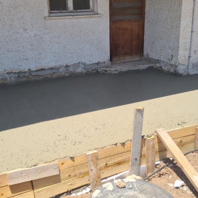 יציקת בטון חדשה ליד קיר חיצוני של מבנה