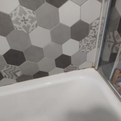 אריחים משושים במקלחת עם צינור מים