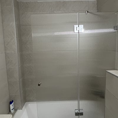 דלת זכוכית למקלחת עם אריחים אפורים