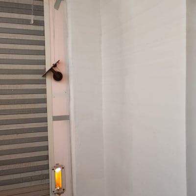 קיר צבוע ליד חלון עם תריס סגור